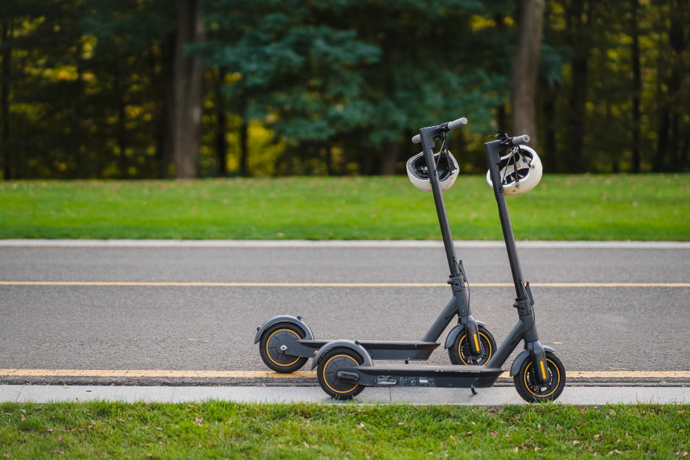 Mobilidade elétrica: Conheça as principais informações sobre veículos elétricos! 2 two electric kick scooters e scooter parked sidelines road