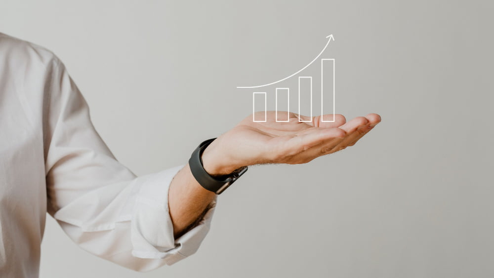 Quais as principais funções do SDR e como se tornar um? 2 digital increasing bar graph with businessman hand overlay