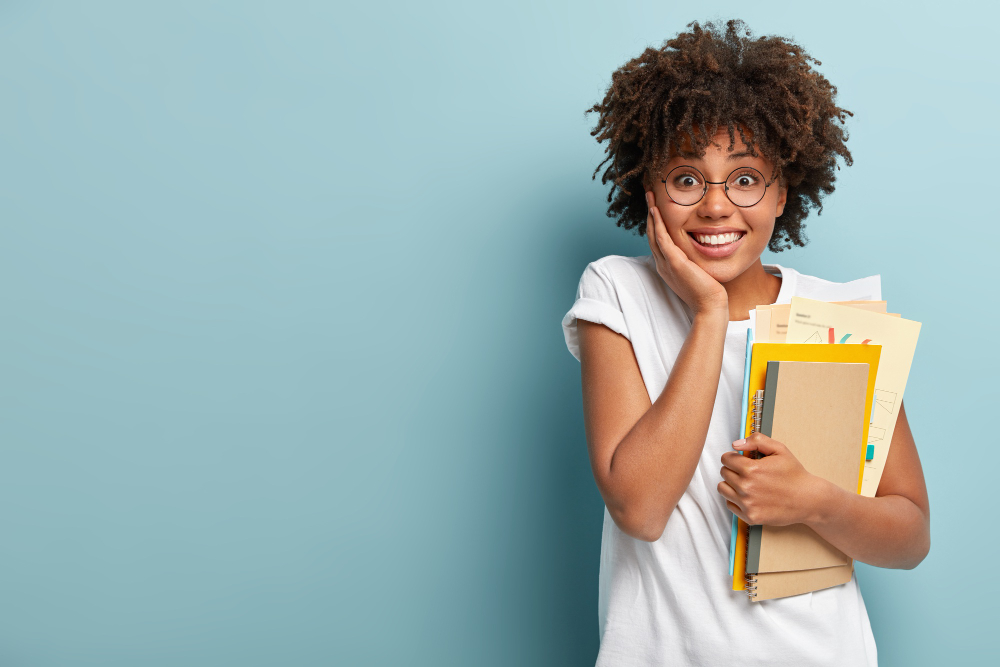 pleasant looking afro american woman holds notepads papers studies college glad finish studying