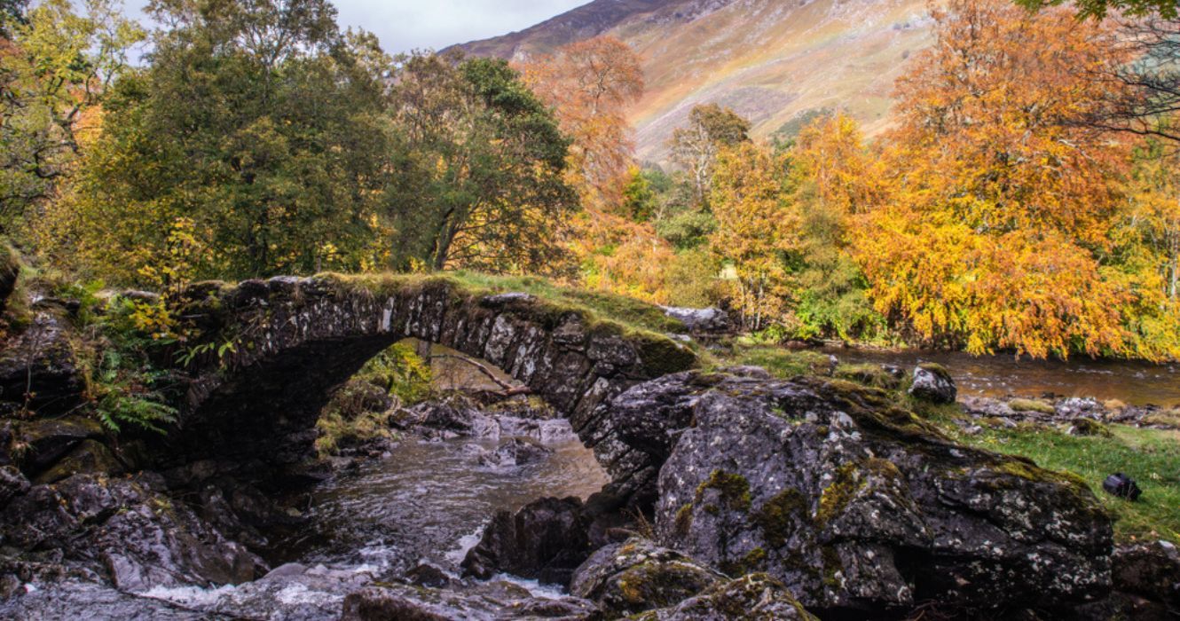 Visitando Aberfeldy: a cidade que ficou famosa por Robert Burns 1 uma ponte sobre um rio em aberfeldy, escócia
