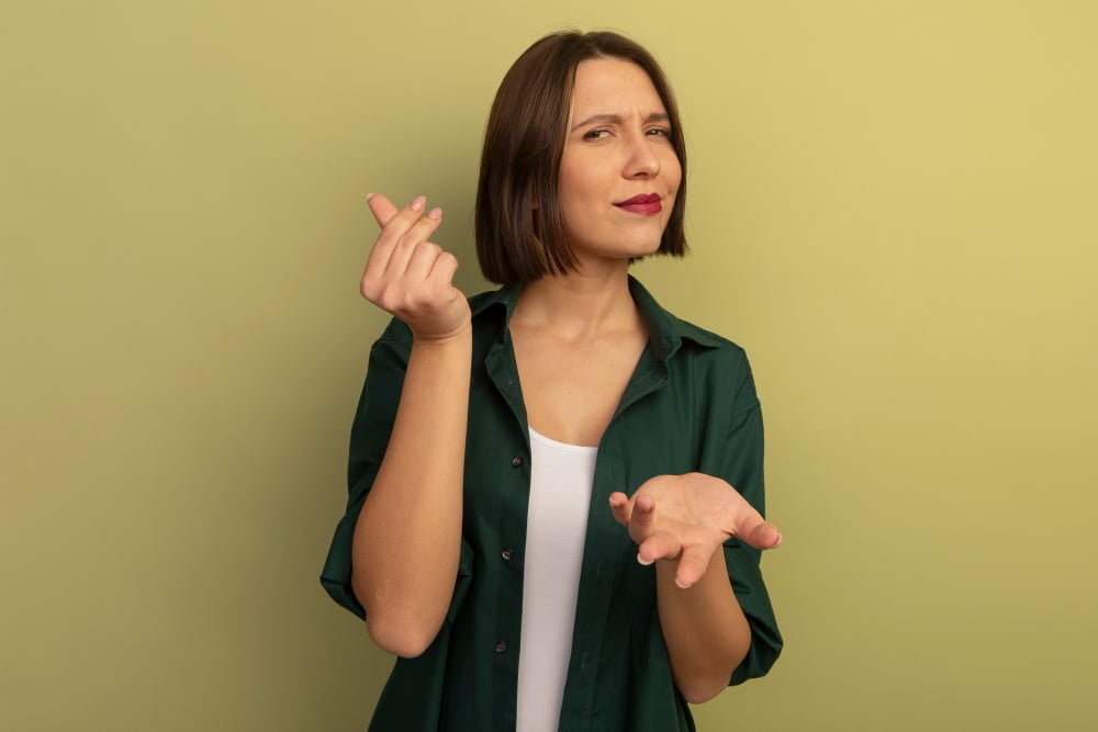 Como fazer sobrar dinheiro no final do mês 3 confident pretty caucasian woman holds hand open gestures money hand sign olive green