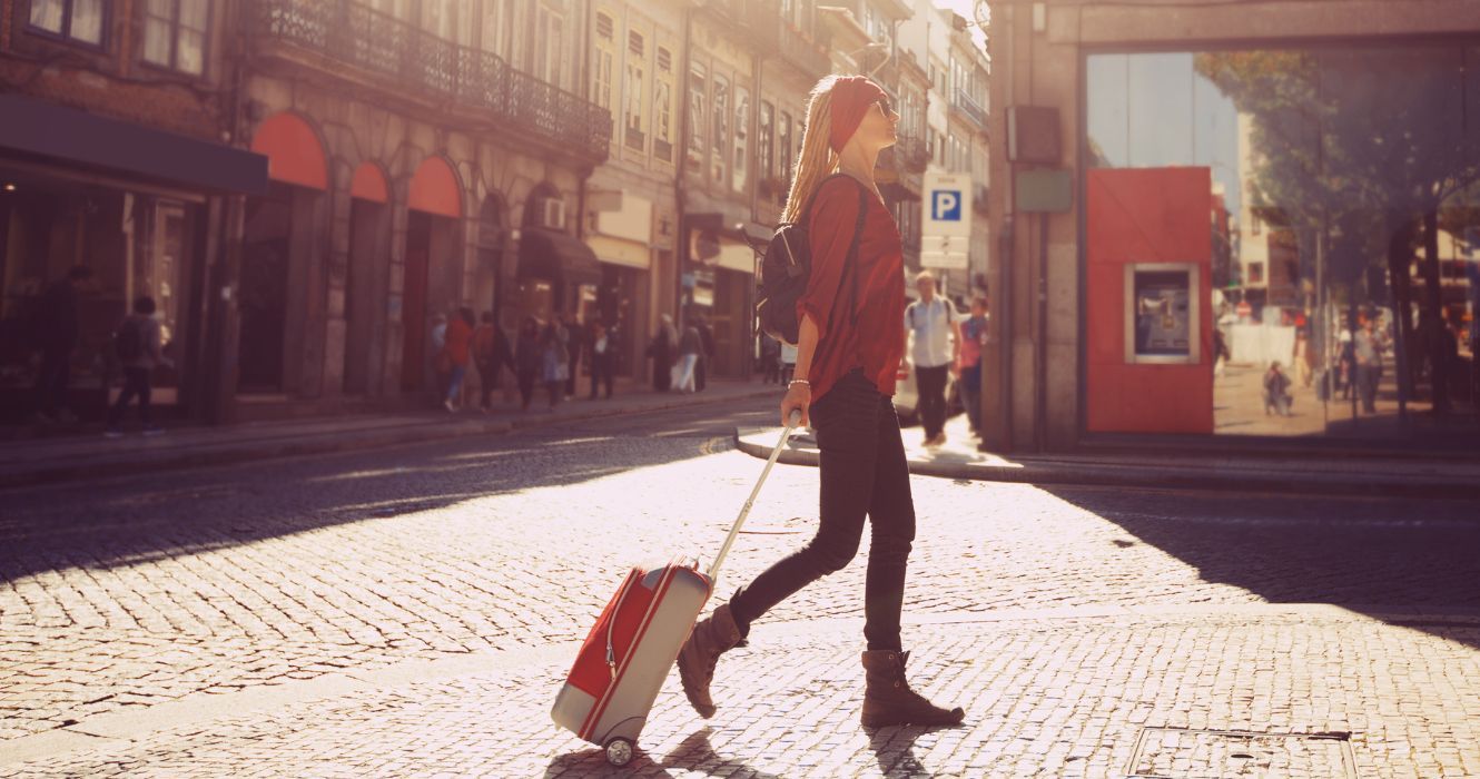 um viajante andando por Roma com bagagem