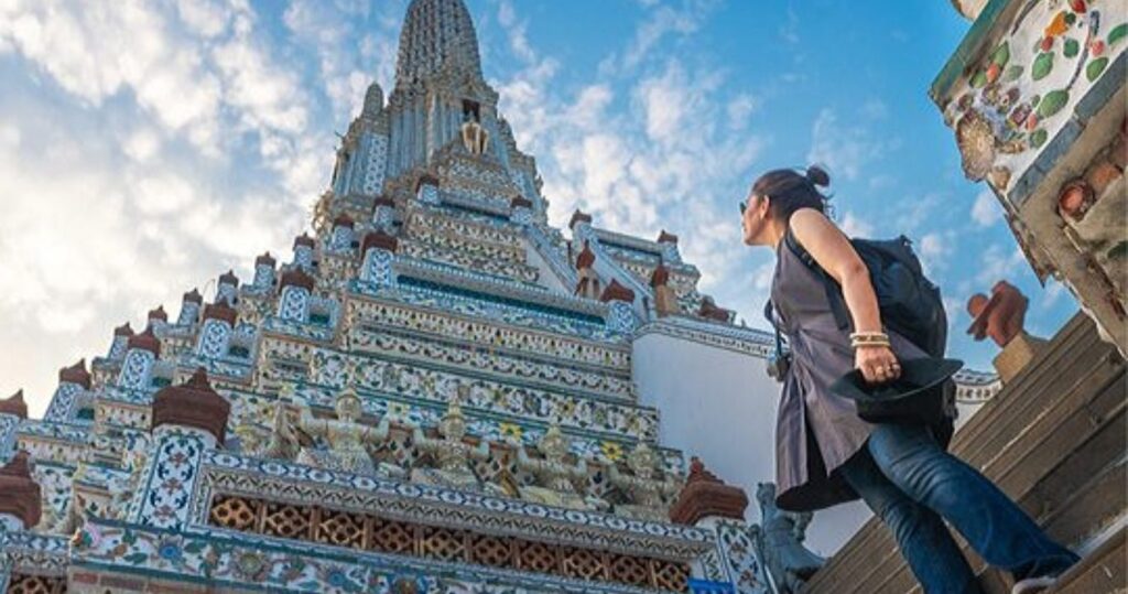 12 coisas que todo viajante precisa fazer antes de ir para a Tailândia 13 a woman looks up at a temple in bangkok