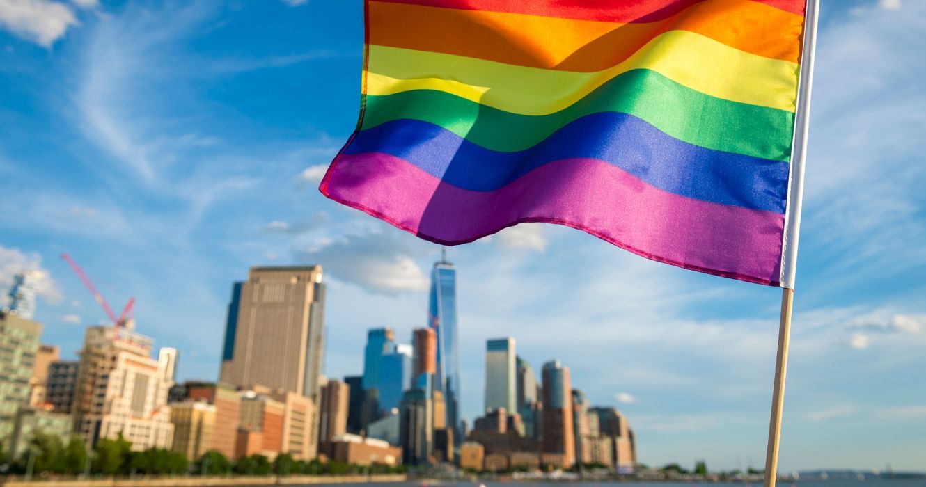 a bandeira do orgulho acenando com o horizonte de Nova York ao fundo
