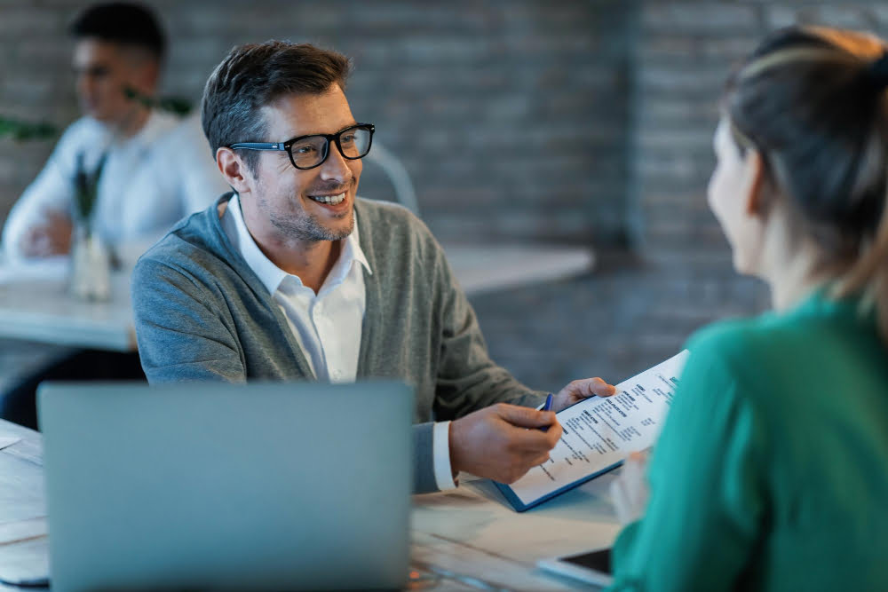 Banco Digital para quem tem o nome sujo 3 happy businessman talking his colleague while going through financial reports office