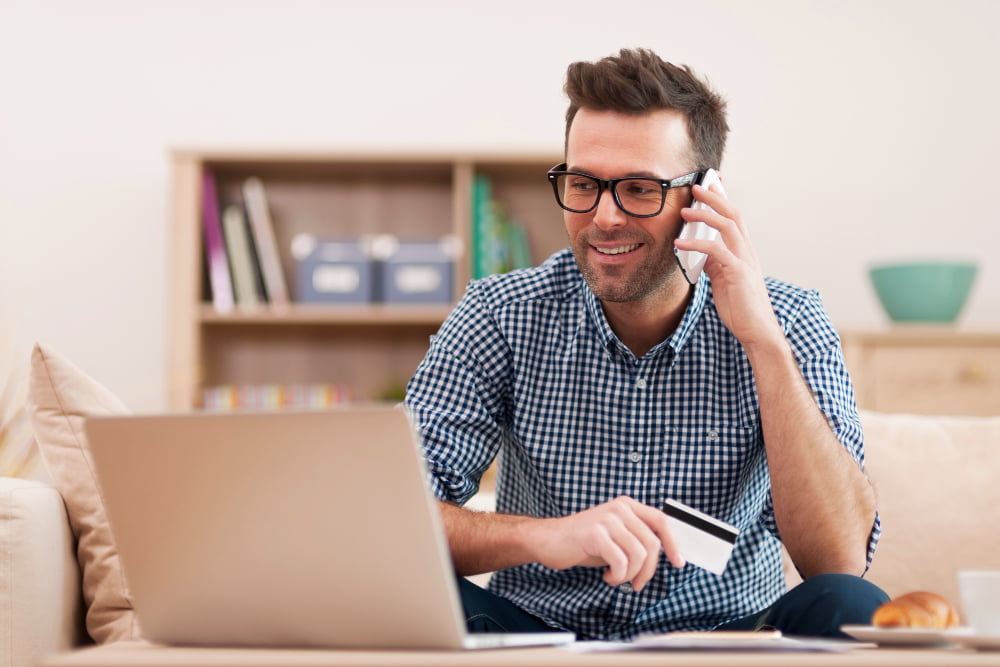 Vale a pena comprar pneu online? Dicas para realizar uma compra segura! 1 homem sorridente fazendo pedido pelo celular