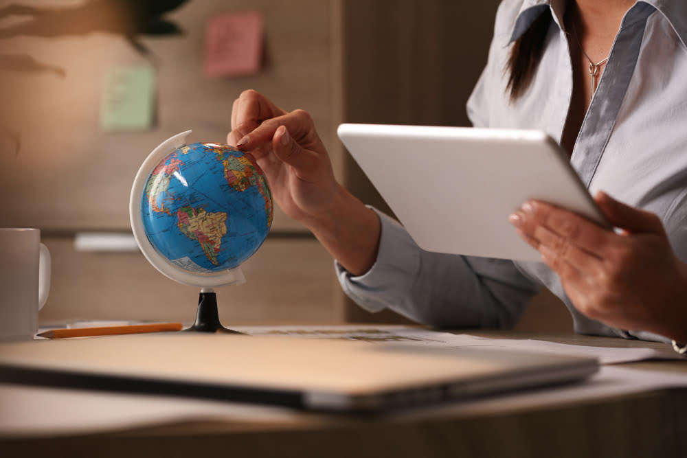 Como fazer intercâmbio na Ásia: Dicas e informações úteis 1 unrecognizable businesswoman using digital tablet while examining globe planning her vacation